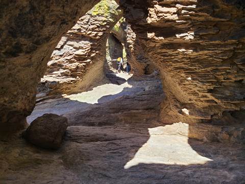 2 hikers hike up a tunnel formation
