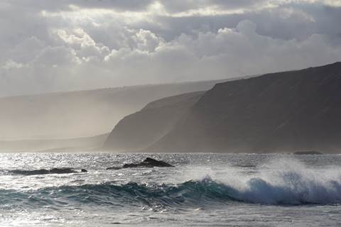Ocean waves and coastal cliffs shortly before sunset