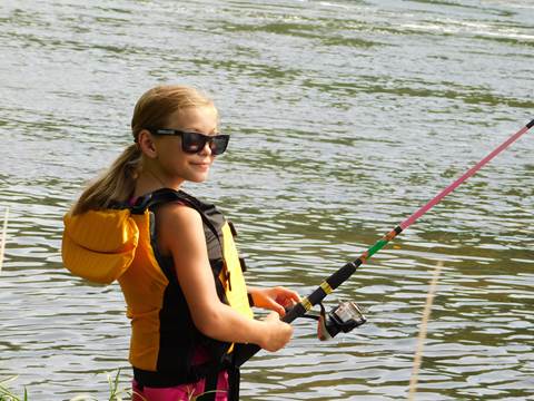 girl wearing life jacket and fishing in a river