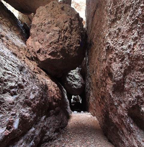 Large boulder wedged in narrow rock canyon.